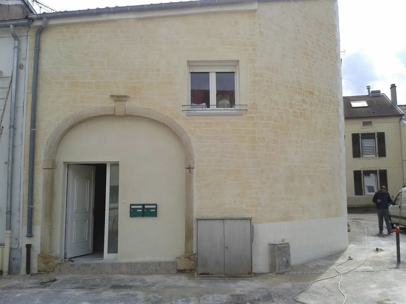 Façade décorée en fausse pierre avec arche d'entrée, technique enduit de chaux taillé à la main